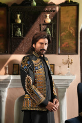 Groom in traditional black Pashto dress posing confidently