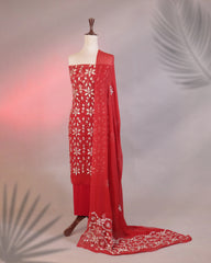 Red saree with white floral embroidery on a mannequin against a neutral background