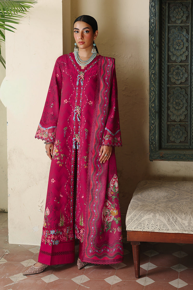 Woman wearing a pink embroidered traditional outfit in an indoor setting.