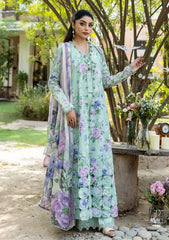 Woman in a floral dress standing outdoors with greenery and a bench in the background